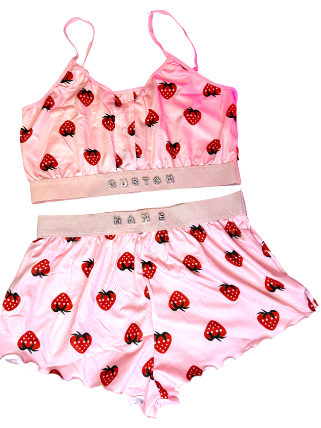 Pink sports bra and shorts set with strawberry pattern on a white background