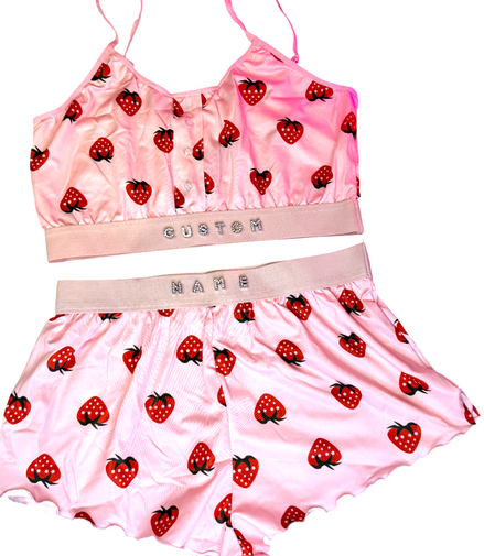 Pink sports bra and shorts set with strawberry pattern on a white background