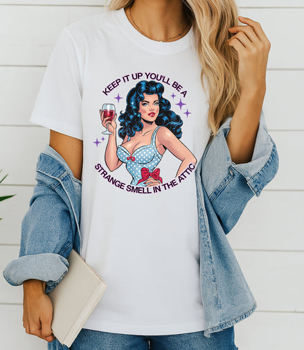Woman wearing white retro pin-up graphic T-shirt with Keep It Up You’ll Be a Strange Smell in the Attic text, handmade organic cotton edgy fashion tee