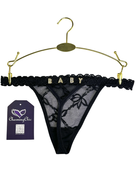 Black lace thong on a gold hanger with 'Charming Chic' tag.