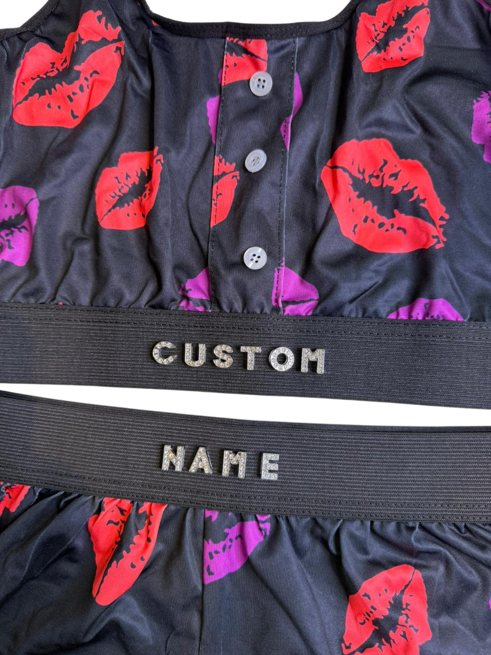 Black garment with red and pink floral patterns and 'Custom Name' label.