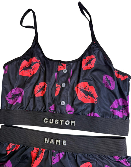 Black sports bra and shorts with red and purple lip prints on a white background