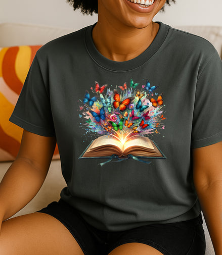 Women wearing a dark gray t-shirt with a colorful graphic of butterflies emerging from an open book.