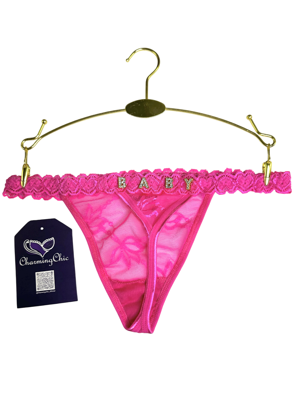 Pink lace thong with 'BABY' text on a gold hanger against a white background
