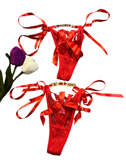 Red satin lingerie set with ribbons on a white background
