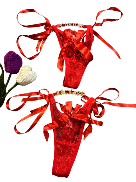 Red satin lingerie set with ribbons on a white background