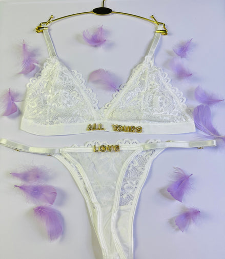 White lace lingerie set with 'All Yours Love' text on a white background with purple flowers.
