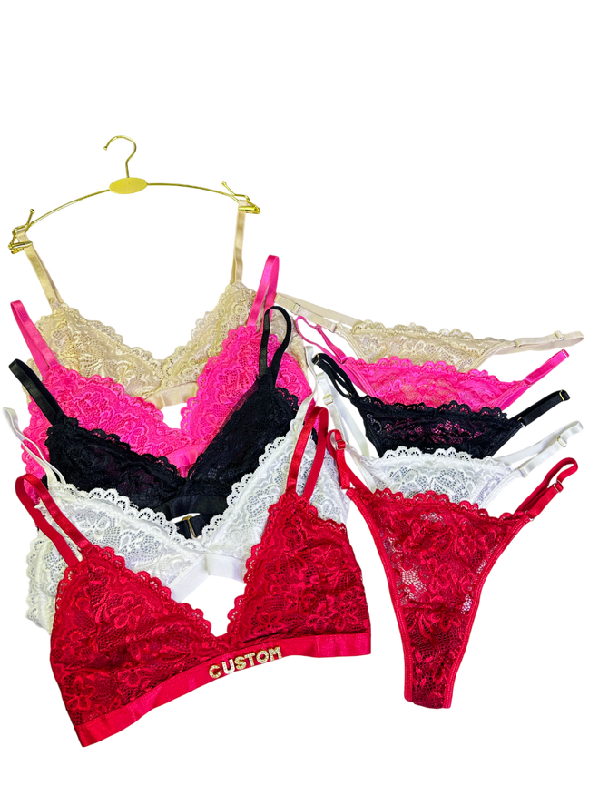 Set of colorful lace lingerie on hangers against a white background